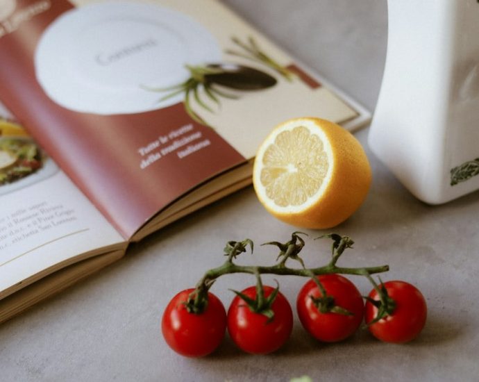 A table topped with a plate of food and a book