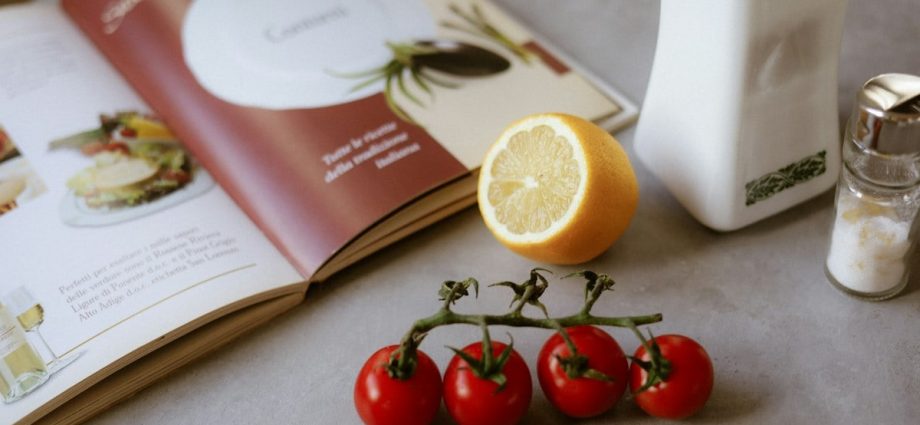 A table topped with a plate of food and a book